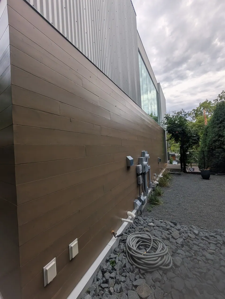A long side wall of stained horizontal wood boards