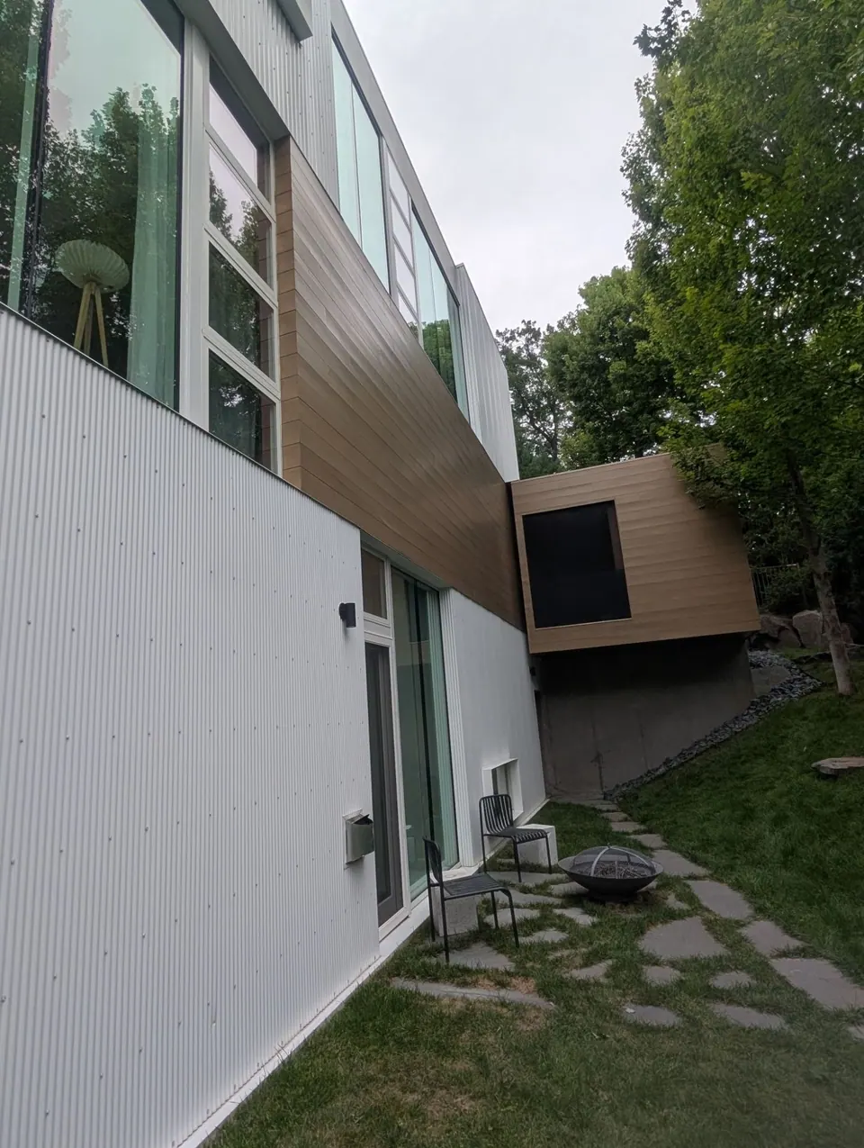 A band of stained wood siding between white metal panels on the rear of the home
