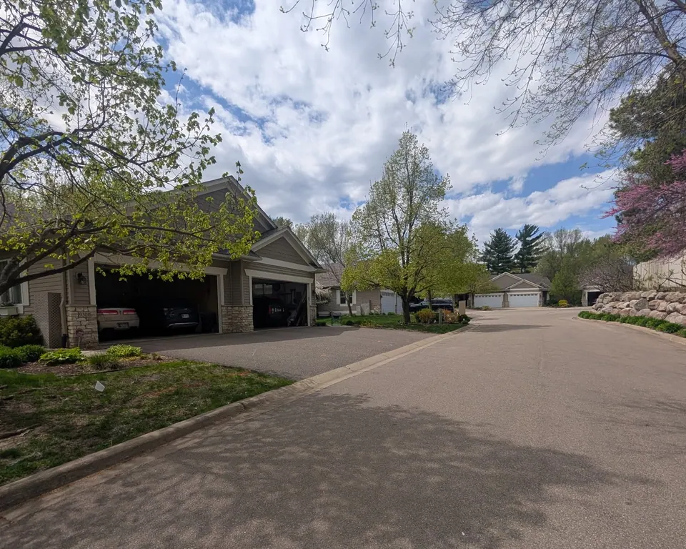 A townhome community with tan siding, stone accents and white garage doors